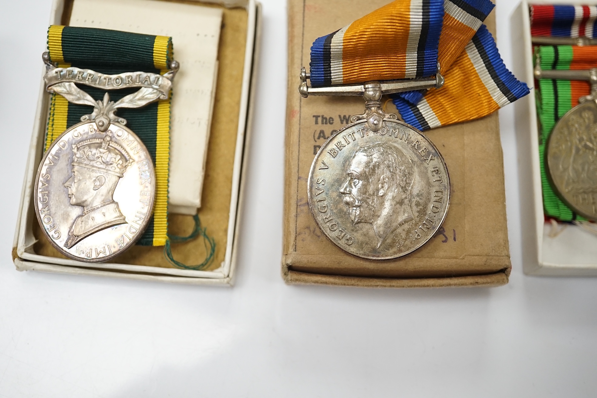 A collection of military interest medals and cloth badges to include a 1914-1918 medal awarded to Lieut. W. C. Griffith and an unnamed 1910-1935 medal. Condition - varies